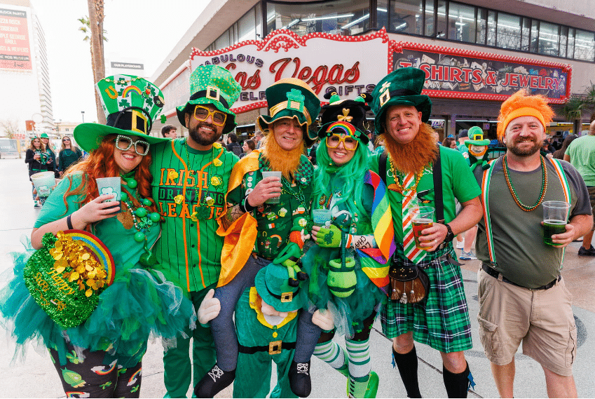 A group of six people celebrating St. Patrick's Day at Fremont Street Experience.