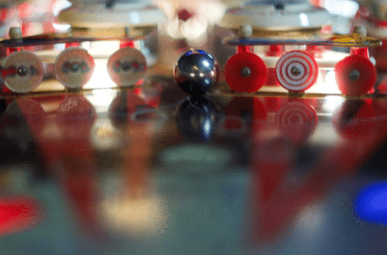 up close photo of a pinball inside a pinball machine, next to the levers.