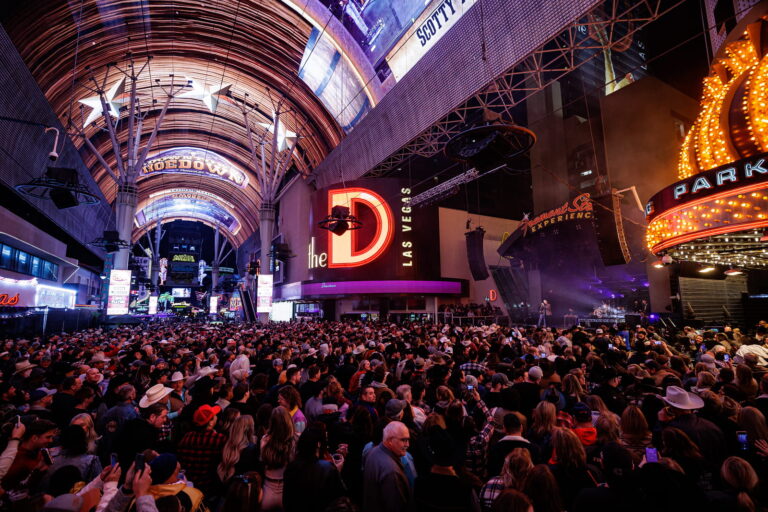 The slotzilla zipline under the led canopy shown above a full crowd at a downtown rocks concert.