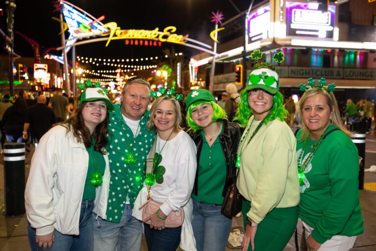 A group decked out in green poses together at a previous saint patrick’s day event at fremont street experience.