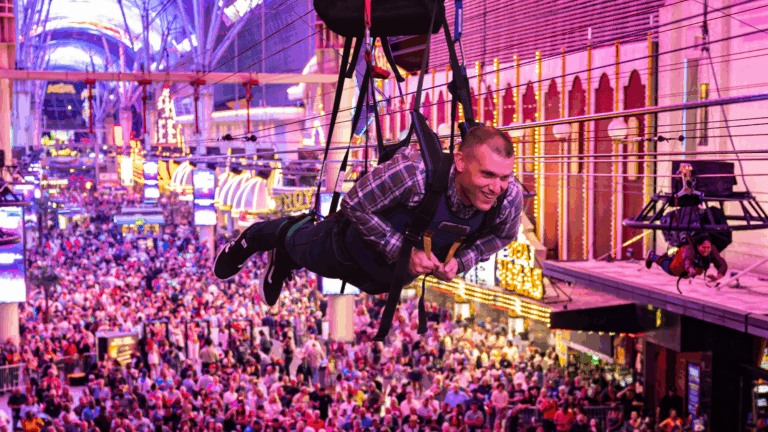 Guy flying the Zoomline at Fremont Street Experience over concert crowds