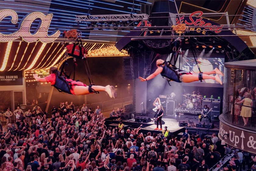 people ziplining above fremont street concert